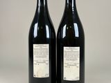 two bottles of wine sitting next to each other on a table