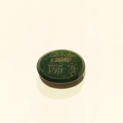 une photo d'une pièce en jade vert posée sur une surface blanche