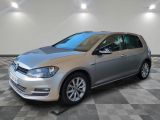 Une Volkswagen Golf argentée est garée dans une pièce dont le sol est en damier.