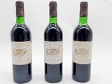 trois bouteilles de vin sont alignées sur une surface blanche