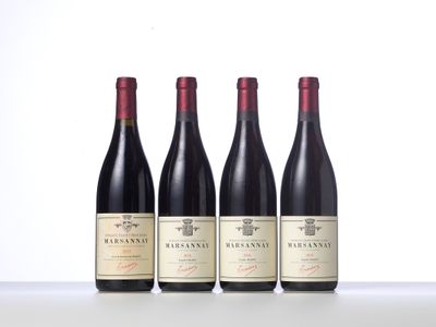 three bottles of wine are lined up on a table