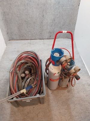 deux types différents de bouteilles de gaz et de tuyaux posés par terre