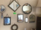 many different mirrors on the wall above a table