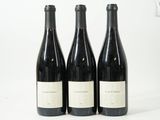 trois bouteilles de vin sont alignées sur une surface blanche