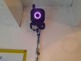 a purple traffic light on the wall next to a sign