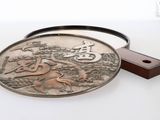 une boucle de ceinture en métal sur laquelle est représenté un cheval