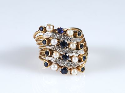 a close up of a ring with pearls and sapphires