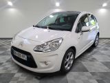 la petite voiture blanche est garée sur un sol en damier