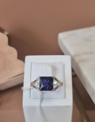 a ring with a blue stone in a box on a table