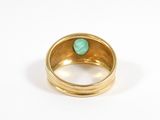 an image of a gold ring with a green stone in the middle