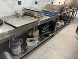 une cuisine avec de nombreux plans de travail en inox