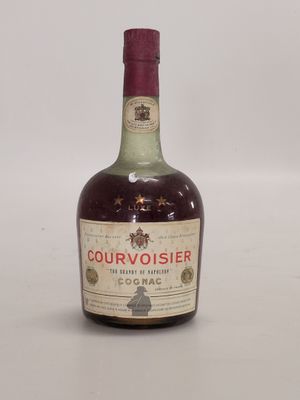 une vieille bouteille d'alcool posée sur une table blanche