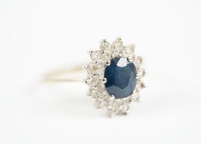 a close up of a sapphire and diamond ring on a white background