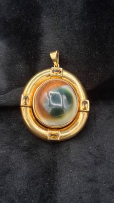 une image représentant un pendentif plaqué or orné d'une horloge