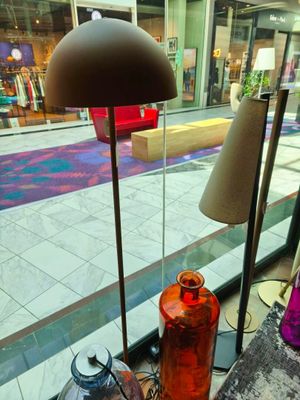 une lampe posée sur une table devant une fenêtre