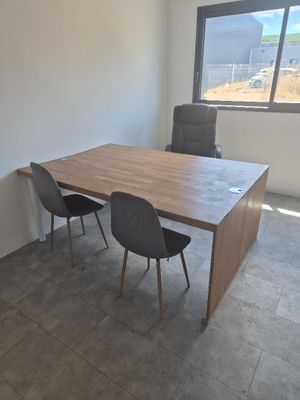 une table et deux chaises dans une pièce dotée d'une grande fenêtre