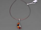 collier en argent avec un pendentif en verre rouge et noir, monté sur un cordon rouge