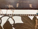 a wooden bench with a metal frame and a leaf design on it