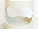 a small white table with wheels on the floor