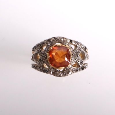 une image représentant une bague ornée d'une pierre orange entourée de diamants