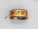 une image représentant un bracelet doré et noir orné d'éléphants