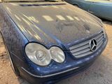 a dirty car parked in a garage with other cars in the background