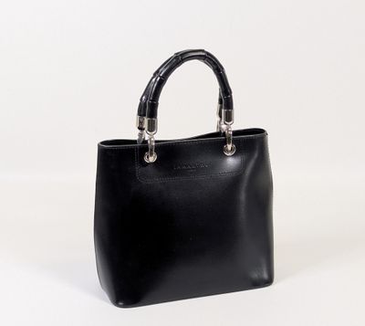 a black leather handbag with a metal handle on a white background
