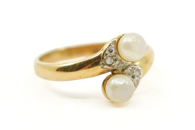 gros plan d'une bague en or avec des perles et des diamants