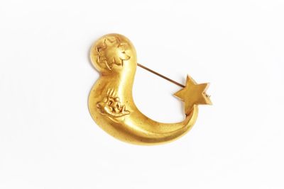 broche en forme de croissant doré, avec une étoile et une lune au centre