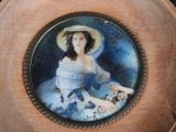 a picture of a woman in a blue dress and hat on a plate