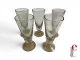 four empty wine glasses sitting on a white surface