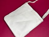 a white purse on a pink background