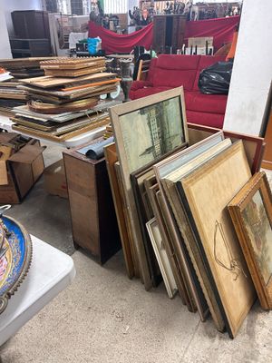 beaucoup d'œuvres d'art, encadrées ou non, posées par terre