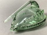 translucent green glass heart shaped object with a metal handle