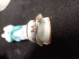 a small figurine of a woman holding a cup