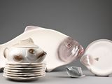une assiette blanche sur laquelle est posé un poisson, à côté d'une autre assiette blanche sur laquelle est posé un poisson
