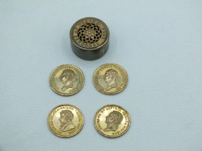 quatre pièces de monnaie britanniques posées sur une table, près d'un siphon