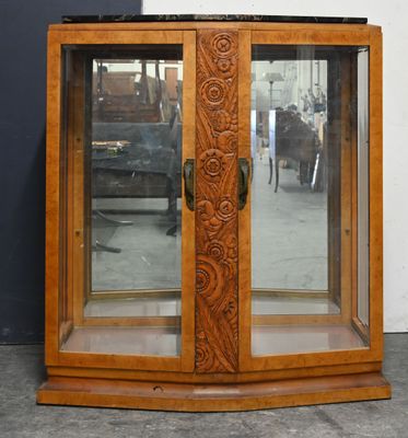 une armoire en bois avec une porte vitrée et une horloge posée dessus