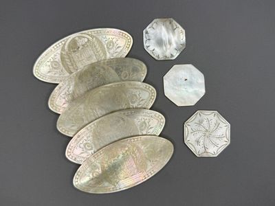 plusieurs pièces d'argent et un caillou posés sur une surface grise