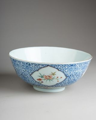 blue and white bowl with flowers and leaves on it