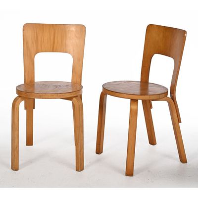 deux chaises en bois assises l'une à côté de l'autre sur une surface blanche