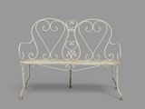 an image of a white iron bench with two hearts on it