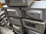 plusieurs fours à micro-ondes empilés les uns sur les autres dans un entrepôt