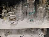 bottles and glasses on a shelf in a store with labels on them