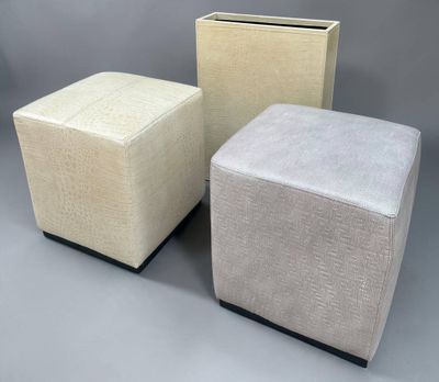 three different colored stools sitting next to each other on a gray surface