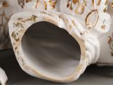 a close up of a white vase with gold decorations