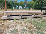 a pile of wood sitting on the ground next to a fence
