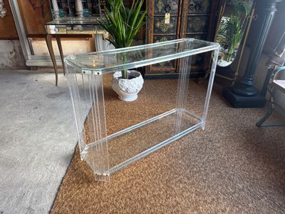 a clear glass table with a vase on top of it