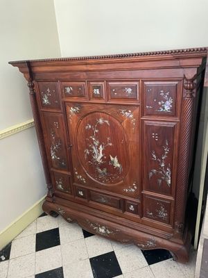 a wooden cabinet that has been left in the corner of the room