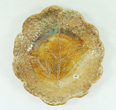 a plate with a leaf on it on a white surface